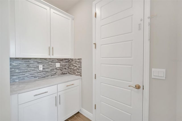 interior space with white cabinetry, tasteful backsplash, and light hardwood / wood-style floors