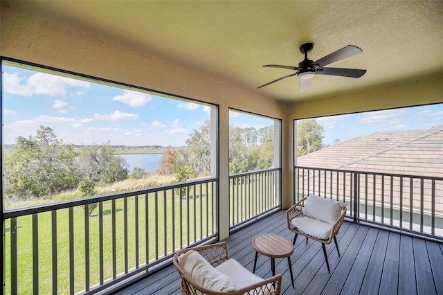 sunroom / solarium with a water view and ceiling fan