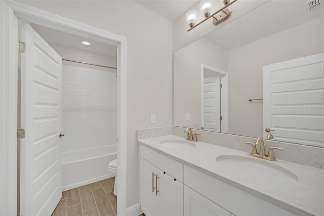 full bathroom with tiled shower / bath, vanity, and toilet