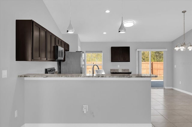 kitchen featuring stainless steel appliances, kitchen peninsula, vaulted ceiling, and plenty of natural light