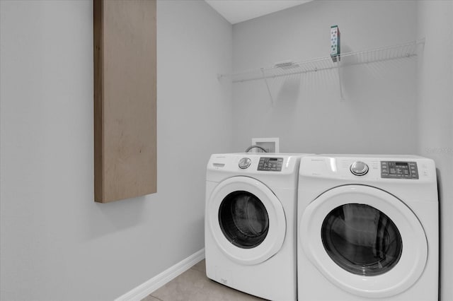 laundry room featuring washer and clothes dryer and light tile patterned floors