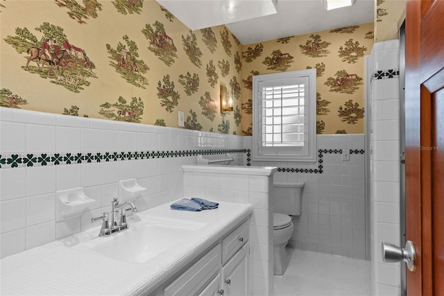 625 Brechin Dr, Winter Park, FL 32792 - full bath with wallpapered walls, a wainscoted wall, toilet, tile walls, and vanity