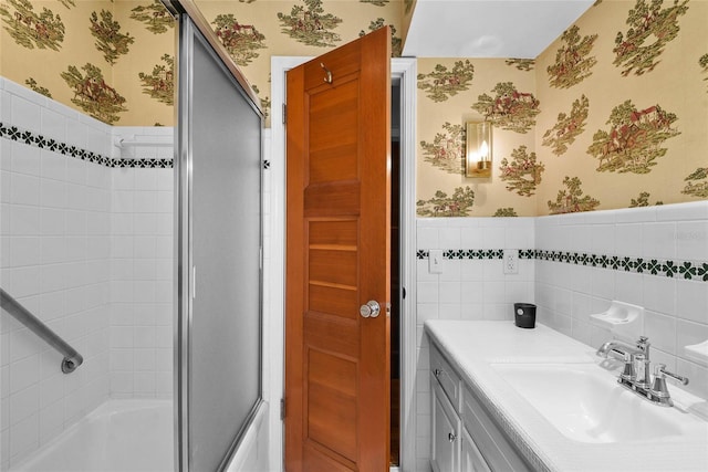 625 Brechin Dr, Winter Park, FL 32792 - full bath featuring wallpapered walls, a wainscoted wall, vanity, and combined bath / shower with glass door