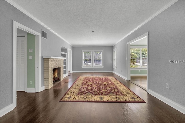 unfurnished living room featuring plenty of natural light, ornamental molding, dark hardwood / wood-style floors, and a textured ceiling