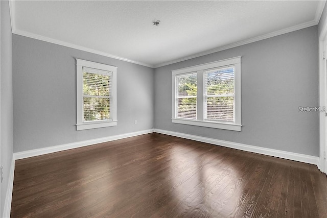 empty room with dark wood-type flooring and ornamental molding