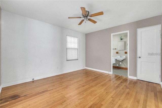 unfurnished room with sink, light hardwood / wood-style floors, and ceiling fan