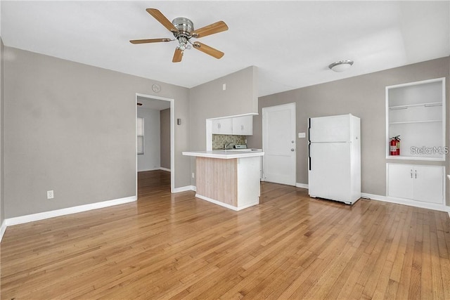 kitchen featuring tasteful backsplash, white cabinets, white refrigerator, ceiling fan, and light hardwood / wood-style floors