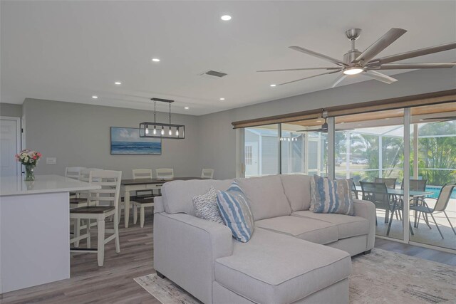 living room with ceiling fan and light wood-type flooring