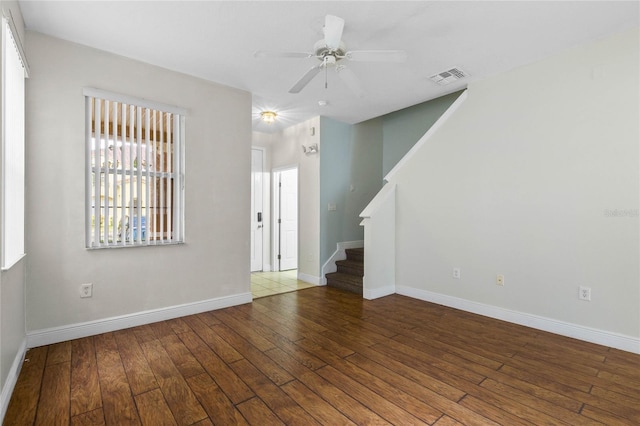 empty room featuring dark wood-type flooring and ceiling fan