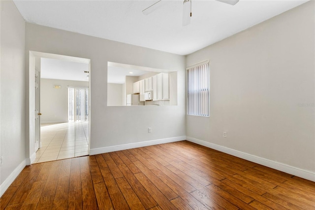 empty room with ceiling fan and light wood-type flooring