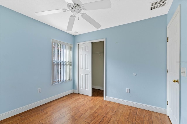 unfurnished bedroom featuring ceiling fan, a closet, and light wood-type flooring