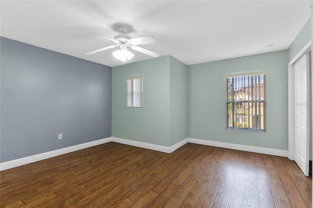 empty room featuring ceiling fan and dark hardwood / wood-style flooring