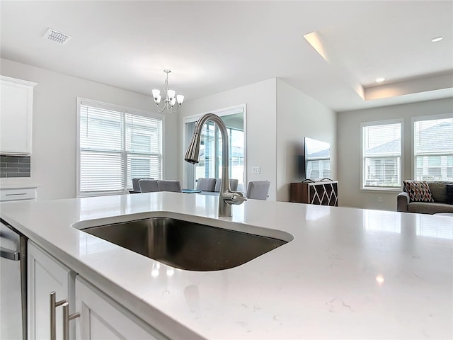 kitchen featuring white cabinetry, sink, a wealth of natural light, and an inviting chandelier