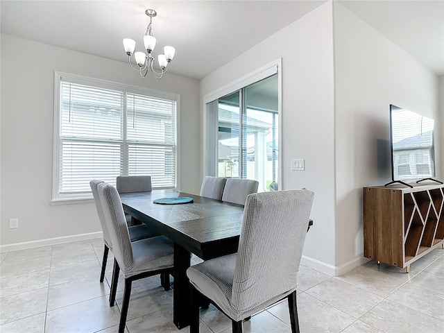 dining space with light tile patterned floors and a chandelier