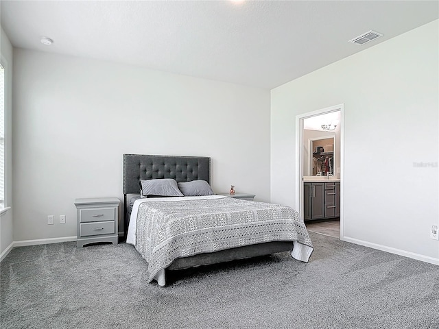 bedroom with light colored carpet and ensuite bathroom