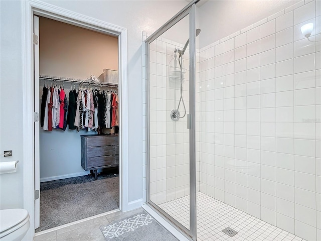 bathroom with toilet, an enclosed shower, and tile patterned flooring