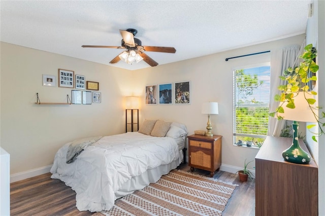 bedroom with dark wood-type flooring, a textured ceiling, and ceiling fan