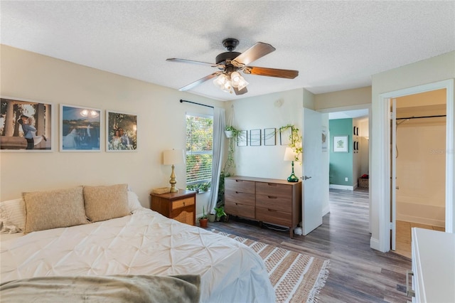 bedroom with ceiling fan, dark hardwood / wood-style floors, and a textured ceiling