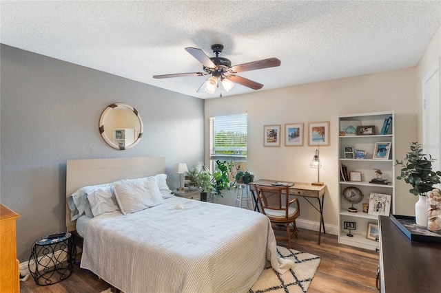 bedroom with hardwood / wood-style flooring, ceiling fan, and a textured ceiling