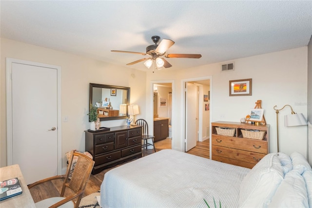 bedroom with light hardwood / wood-style flooring, ceiling fan, and ensuite bathroom