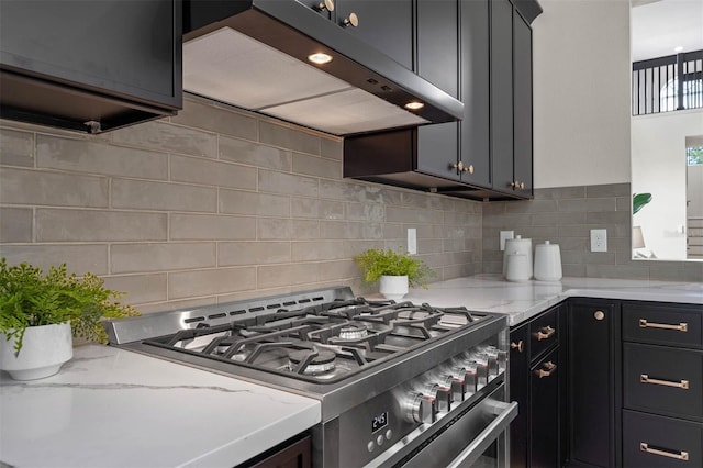 kitchen with light stone countertops, extractor fan, backsplash, and gas range