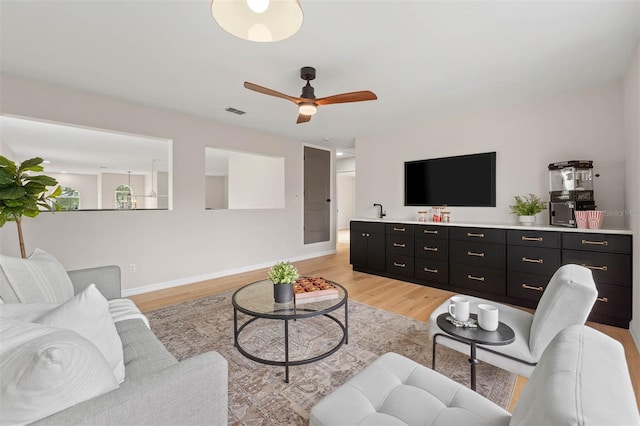 living room with light wood-type flooring and ceiling fan