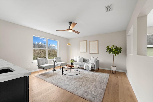 living room with ceiling fan and light wood-type flooring