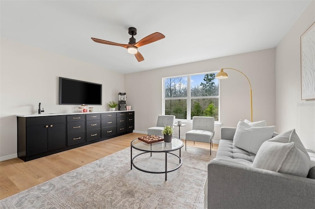 living room with ceiling fan and light hardwood / wood-style flooring