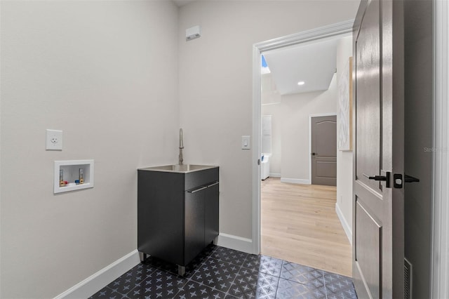 washroom with sink, hookup for a washing machine, and dark hardwood / wood-style flooring