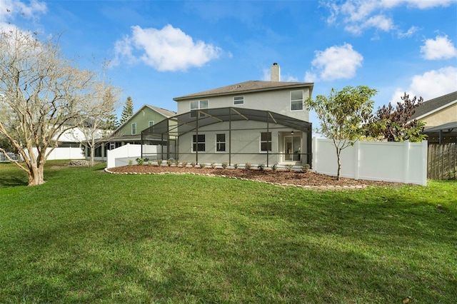 rear view of property with a yard and glass enclosure