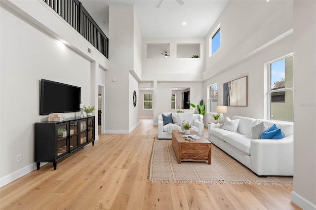 living room with light hardwood / wood-style floors and a high ceiling