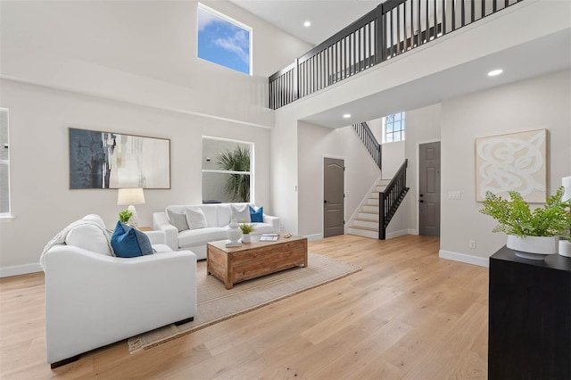 living room with light hardwood / wood-style floors and a high ceiling