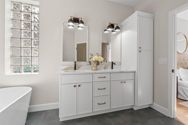 bathroom with tile patterned floors, a tub to relax in, and vanity