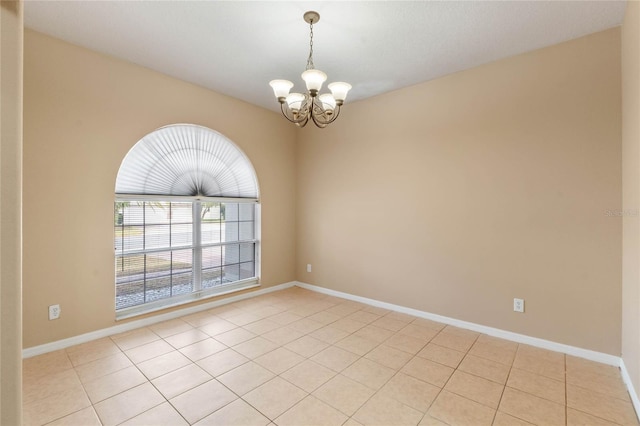 tiled empty room with a notable chandelier