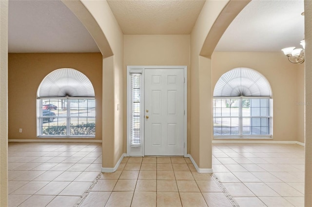 foyer featuring light tile patterned floors and a textured ceiling