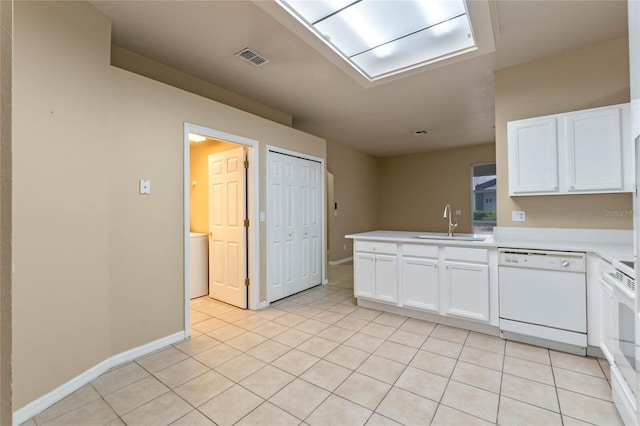 kitchen featuring sink, white cabinets, light tile patterned floors, kitchen peninsula, and white appliances