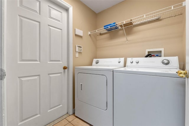 washroom with washer and clothes dryer and light tile patterned floors