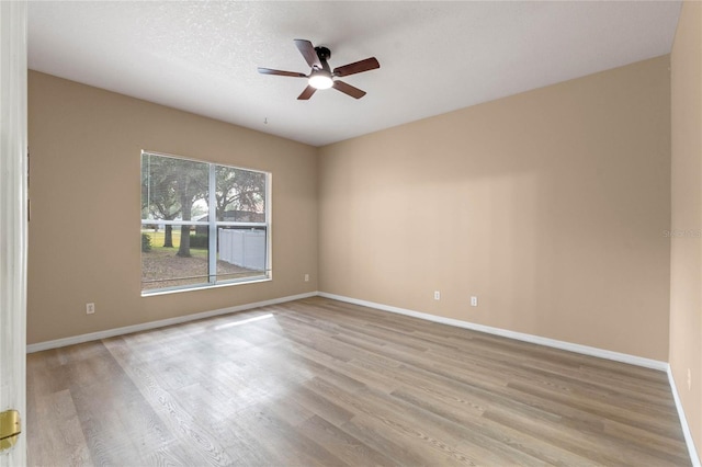 spare room featuring ceiling fan, light hardwood / wood-style flooring, and a textured ceiling