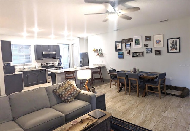 living room with sink and ceiling fan