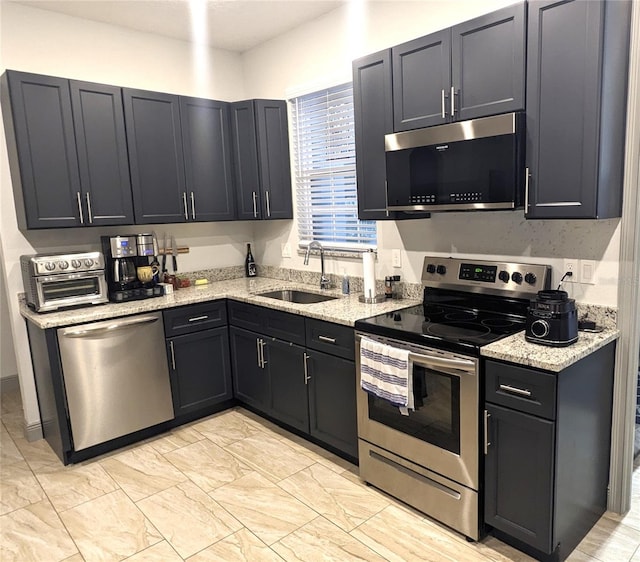 kitchen featuring sink, stainless steel appliances, and light stone countertops