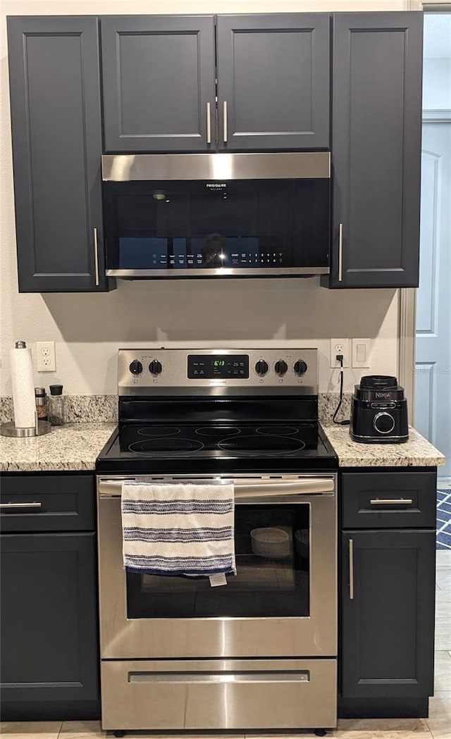 kitchen featuring light stone counters and stainless steel appliances