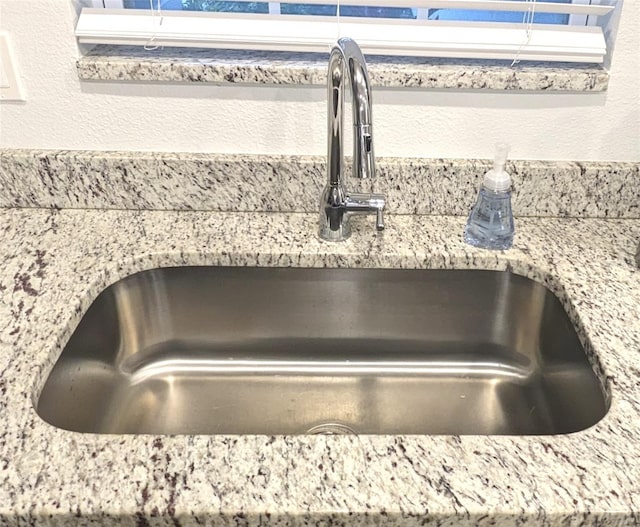 details with light stone countertops and sink