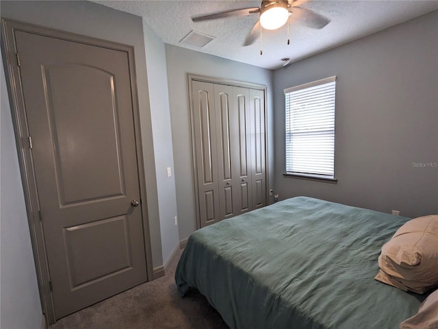 bedroom featuring ceiling fan, carpet floors, a closet, and a textured ceiling