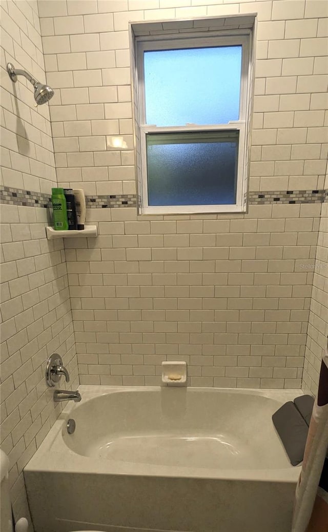 bathroom featuring tiled shower / bath