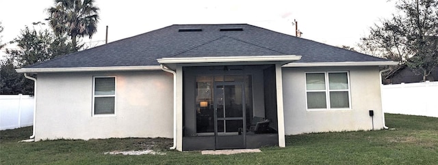 back of house with a yard and a sunroom