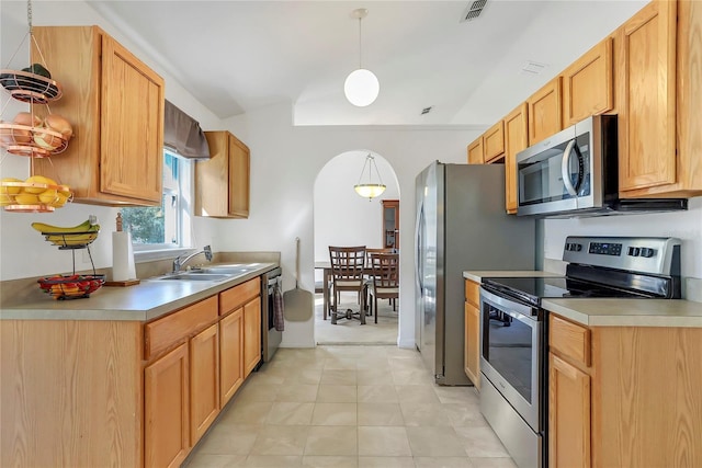 kitchen with pendant lighting, stainless steel appliances, light countertops, visible vents, and a sink