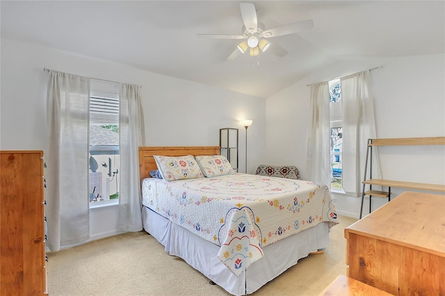 bedroom with vaulted ceiling, ceiling fan, baseboards, and light colored carpet