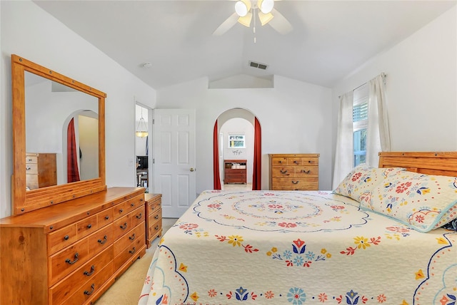 bedroom with light carpet, visible vents, arched walkways, a ceiling fan, and vaulted ceiling