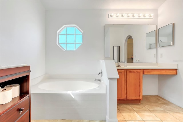 bathroom featuring vanity, tile patterned flooring, and a bath