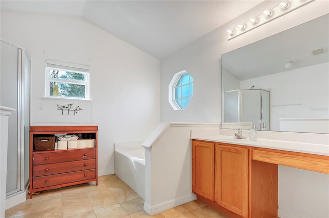 bathroom with lofted ceiling, vanity, a bath, and a healthy amount of sunlight